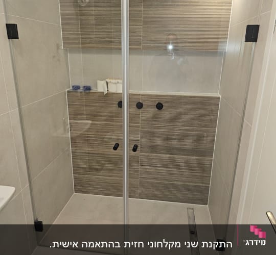 מקלחת עם ראש מקלחת, דלת זכוכית ומדף סבון